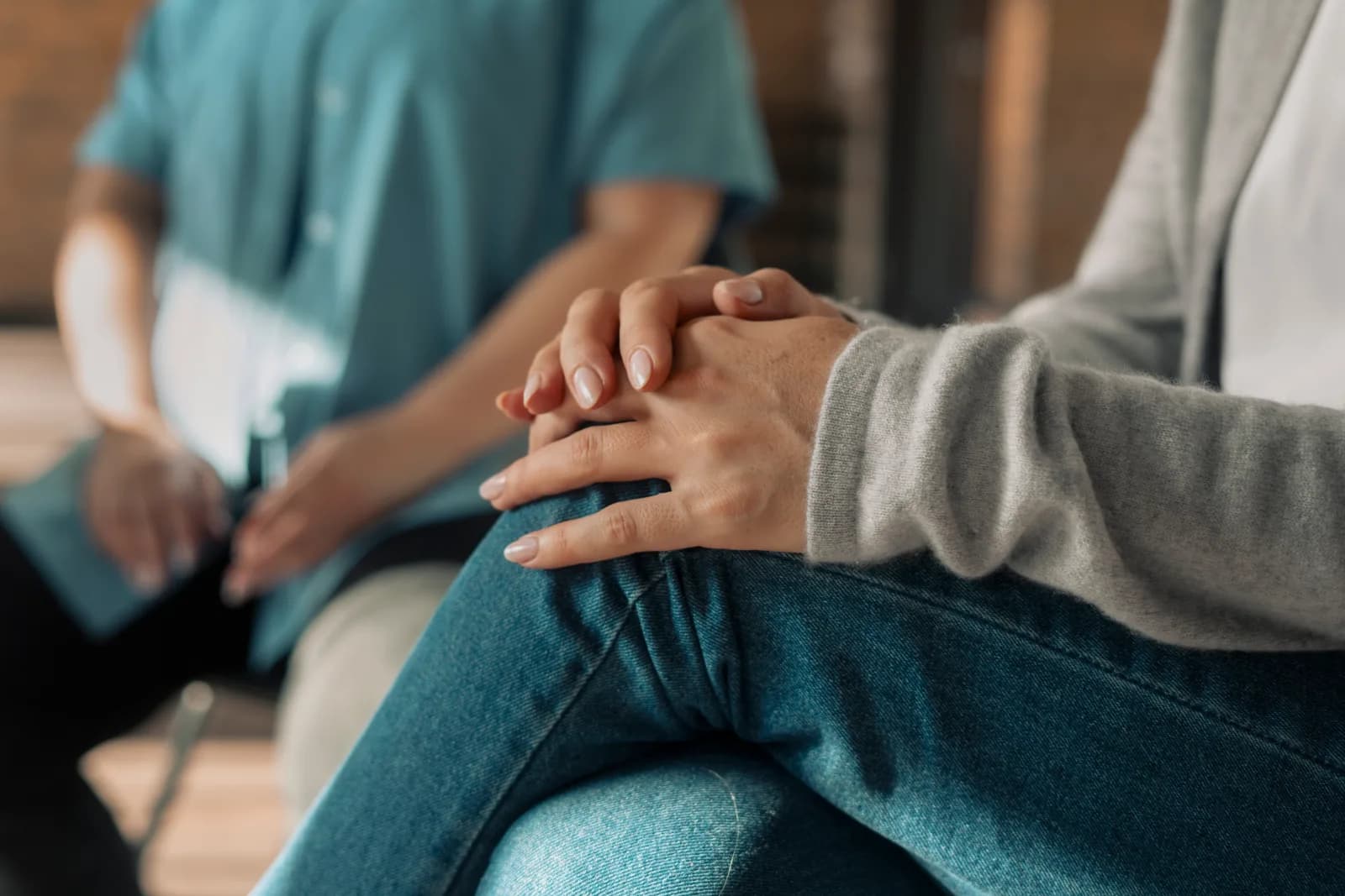 A client's hands resting on their knee during a therapy session