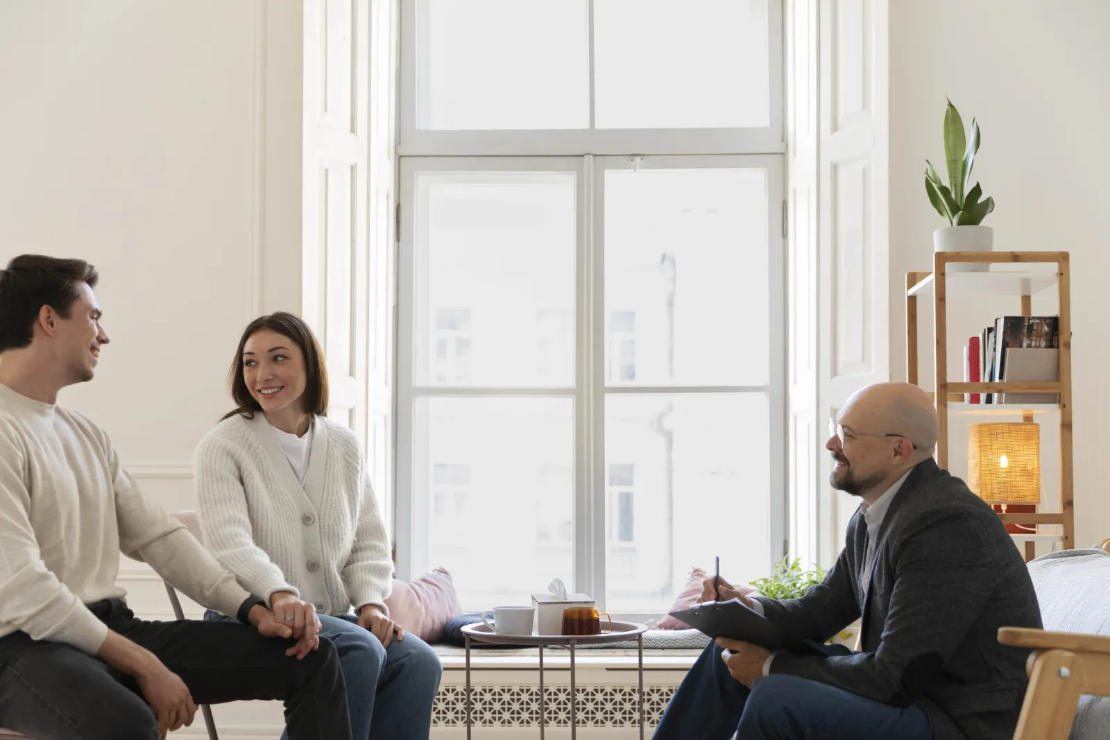 A couple talking with a therapist in a bright office